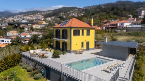 Exterior aerial view of Papaya Villa by LovelyStay, showcasing the beautiful yellow façade, private pool, spacious terrace and breathtaking ocean views in sunny Funchal. Perfect for relaxing holidays.
#PapayaVilla #Funchal #Madeira #OceanView