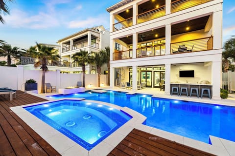 Modern luxury vacation home with stunning pool, spa, and tropical landscaping in an upscale neighborhood setting.
