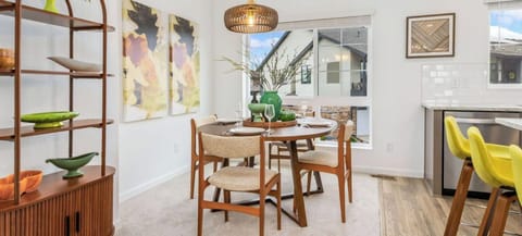 Picture yourself sharing meals at this sunlit dining area, where mid-century style meets modern comfort. Natural light streams through the windows, highlighting the warm wood tones and inviting you to relax in style.
