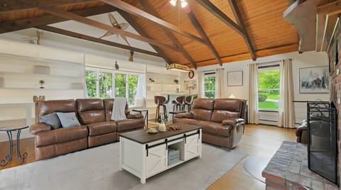 Bright vaulted living room with leather seating and rustic charm