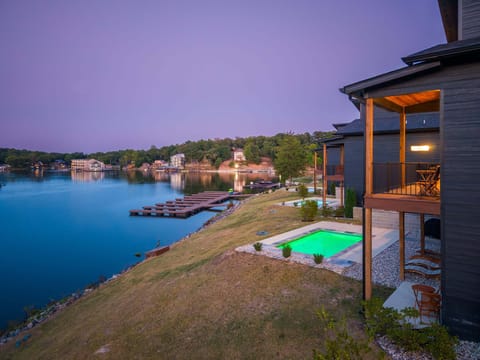 Expansive grassy backyard stretching down toward the tranquil bay, ideal for outdoor evening relaxation.