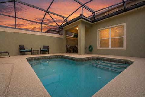 Private screened pool area with seating and sunset views