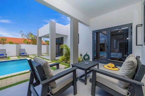 Shared backyard oasis featuring a sparkling pool and lounge area, perfect for soaking up the Aruba sunshine