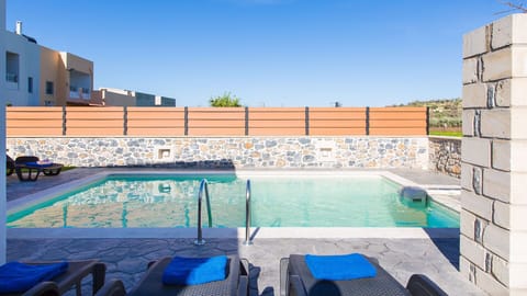 Private swimming pool area with sun beds and umbrellas