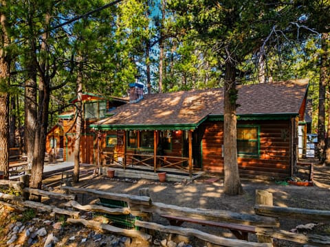 A classic Big Bear cabin surrounded by towering pines, with a welcoming porch and timeless mountain charm.