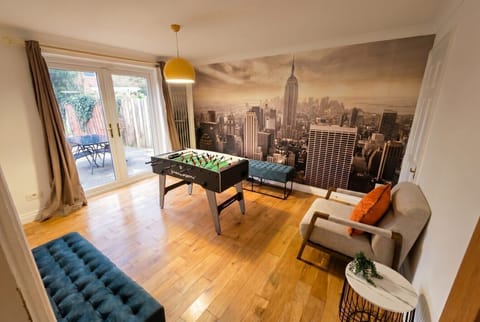 Games room with football table, NYC skyline mural, and garden access.
