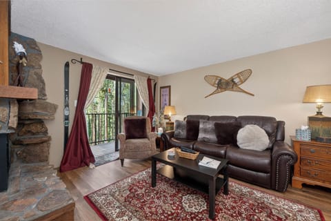 Cozy up in your mountain retreat with rich leather seating, a stone fireplace, and balcony views of nature.