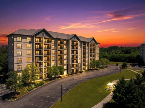 Modern resort-style condo building glowing under a stunning sunset