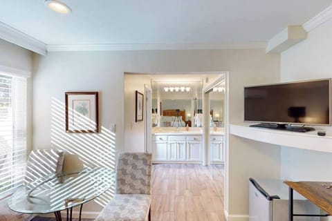 Plan your next Napa Valley winery visit from a bright, airy sitting area with modern furnishings and an entertainment center steps from the bathroom.