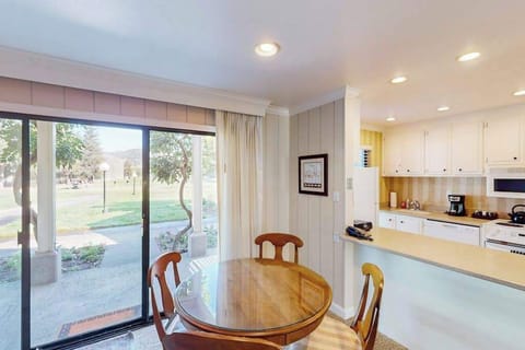 Prep farm-to-table meals in your full kitchen while gazing at the golf course through sliding glass doors — dining table seats four for a relaxed Napa dinner.