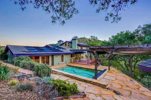 Your private hilltop retreat awaits — pool, pergola, and stone terrace framed by Sonoma County oaks under a golden sunset sky.