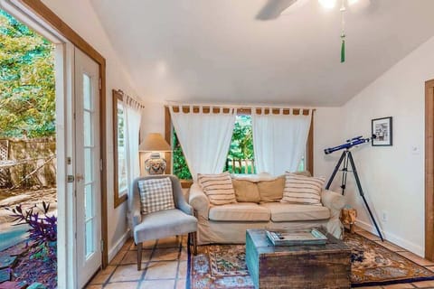 Spot a curious telescope by the window and settle into the cozy sitting area — your cottage living room blends charm with redwood-framed views.