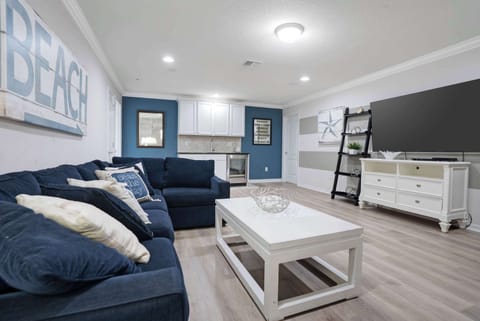 Cozy living area with navy blue seating and a large flat-screen television
