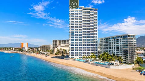Aerial view of Harbor 171 North Tower, featuring multiple beachfront pools, tropical palms, lounge areas, and direct access to the sandy shoreline