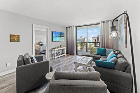 Comfy living room area with large TV and balcony access