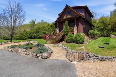 Charming cabin exterior with stone steps and lush mountain greenery.