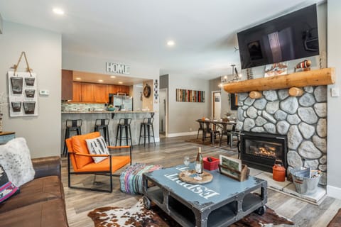 Cozy up by the stone fireplace in your stylish open-concept retreat, where modern comfort meets rustic charm.