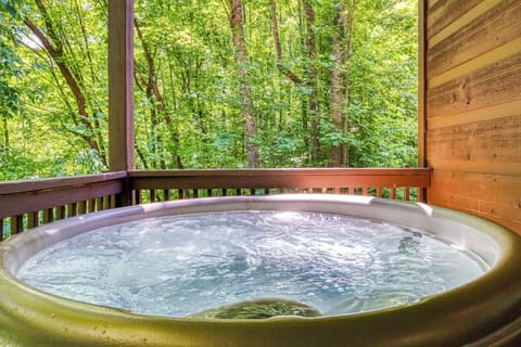 Private forest-view hot tub on a peaceful covered deck