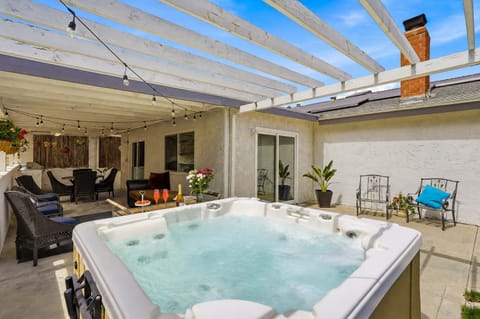 🌙 Private hot tub & covered patio - string lights overhead and open sky above, made for winding down after a full day.