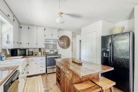 Bright, functional kitchen with ample cabinetry and a warm wood island centerpiece