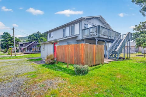 Charming coastal retreat with private upper deck and enclosed outdoor shower area, nestled in a peaceful neighborhood setting.