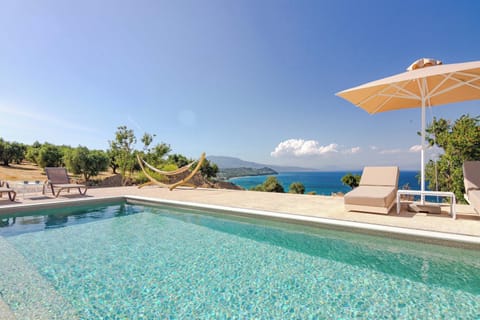 Crystal-Clear Pool with Sunbeds and Coastal Scenery