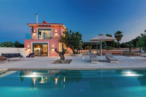 Villa Exterior and Illuminated Pool at Sunset