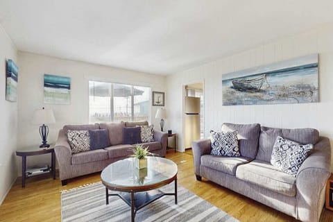 Sink into plush coastal-chic sofas surrounded by ocean-inspired artwork in your sunlit Bodega Bay living room — the perfect spot to unwind after a day exploring the Sonoma Coast.