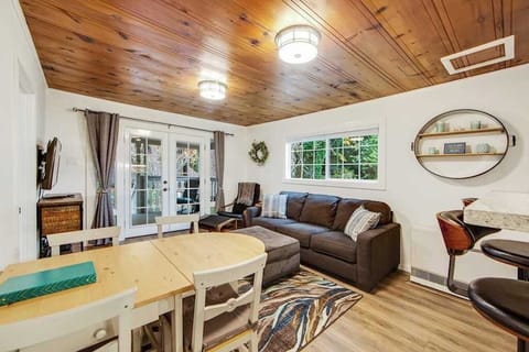 Sink into the cozy sectional beneath warm wood-paneled ceilings after a day exploring Guerneville's redwood trails. French doors flood the room with natural light.