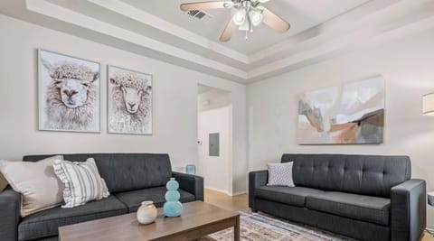 Stretch out in the spacious living room with plush seating and a ceiling fan for year-round comfort.