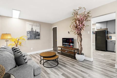 Living room — sofa, smart TV, and a laptop-friendly workspace; the Morganford restaurant strip is out the front door