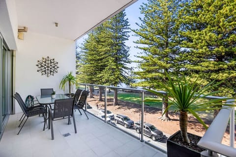 Enjoy alfresco meals on the balcony, where a BBQ and outdoor setting overlook the pine-lined esplanade, with filtered glimpses of the ocean beyond.