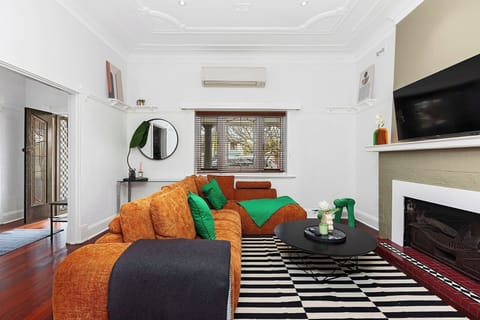 Vibrant & Vacation-Ready! Our living room features an oversized burnt orange sectional—the perfect colorful spot to unwind and recharge.
