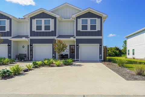 Modern townhome with charming navy and white facade, private garage, and landscaped entrance in peaceful residential neighborhood.