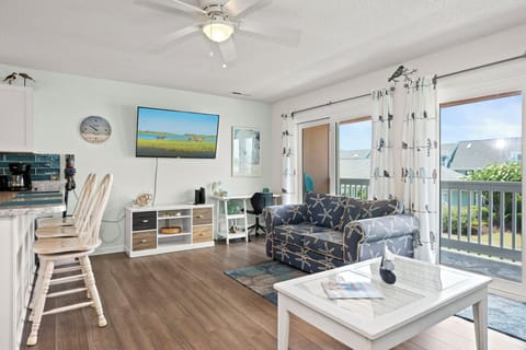 Unwind in your bright coastal living room, where beach-themed touches, a cozy couch, and breezy balcony doors invite you to relax in style and comfort.