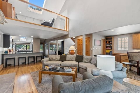 Bright living room with soaring high ceilings, large seating area, and fireplace