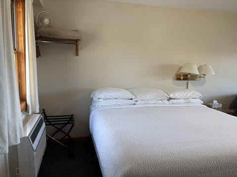 Bright king bedroom with soft lighting, white bedding, and cozy lodge-style comfort.