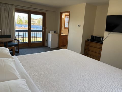 Cozy king bedroom with private balcony views overlooking the waterfront.