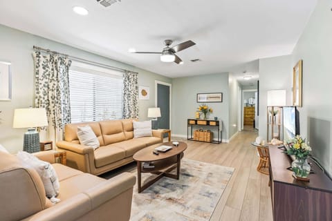 Relax in this modern living room with leather seating and natural light from a large window.