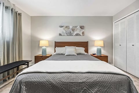 Modern bedroom with a queen bed, bedside lamps, and ample closet space.