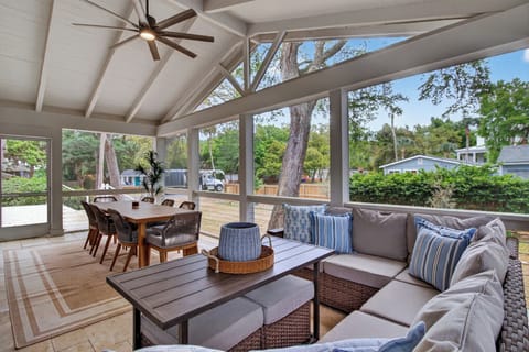 Relax in your bright screened porch with comfortable seating and dining space, perfect for morning coffee or evening meals.
