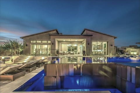 A masterfully lit private oasis designed to unwind by the illuminated water.