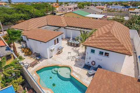 Elevated courtyard view with pool, tiled roofs, and surrounding patio showcasing the private outdoor layout