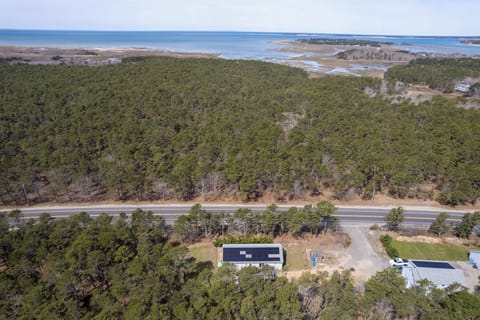 Aerial view showcasing the property's prime location between coastal waters and protected forest lands, offering peaceful surroundings.