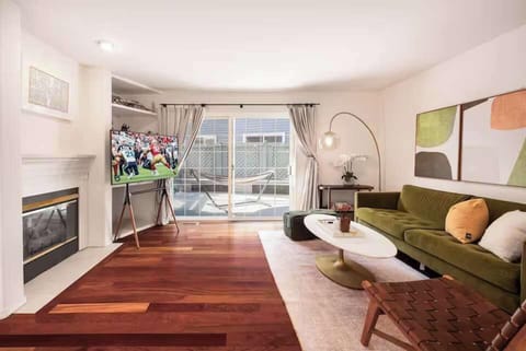 Unwind in a sunlit living space where cozy seating meets warm wood floors—perfect for slow mornings, movie nights, or simply relaxing after a day out.