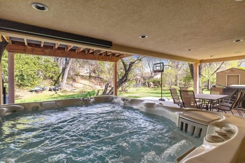 Relax in the covered hot tub with cozy seating, while the backyard offers space for games and gatherings.