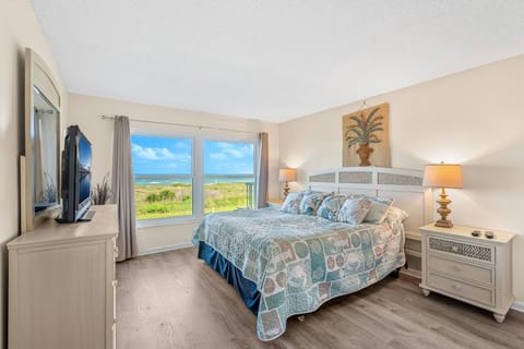 Master bedroom features a king bed with smart TV and stunning ocean views