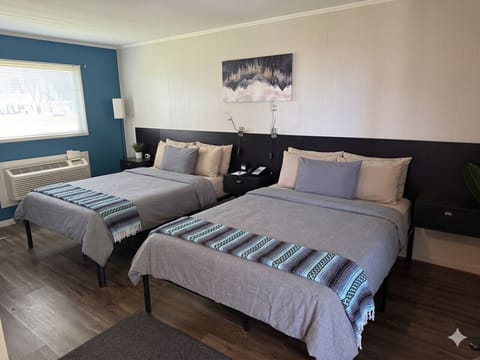 The Naturalist`s Cabin — earthy linens dress two queen beds beneath a framed mountain landscape