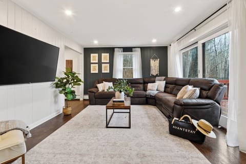 Inviting living room with a leather sectional, warm accents, and bright natural light.