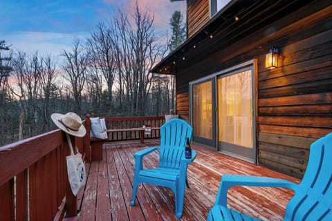 Cozy sunset deck with Adirondack seating and warm cabin glow. (The Hollow)